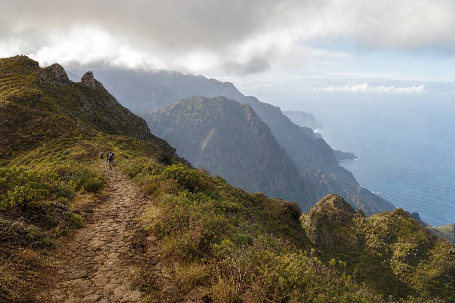 Walkers following a mountain trail through Serra Malagueta